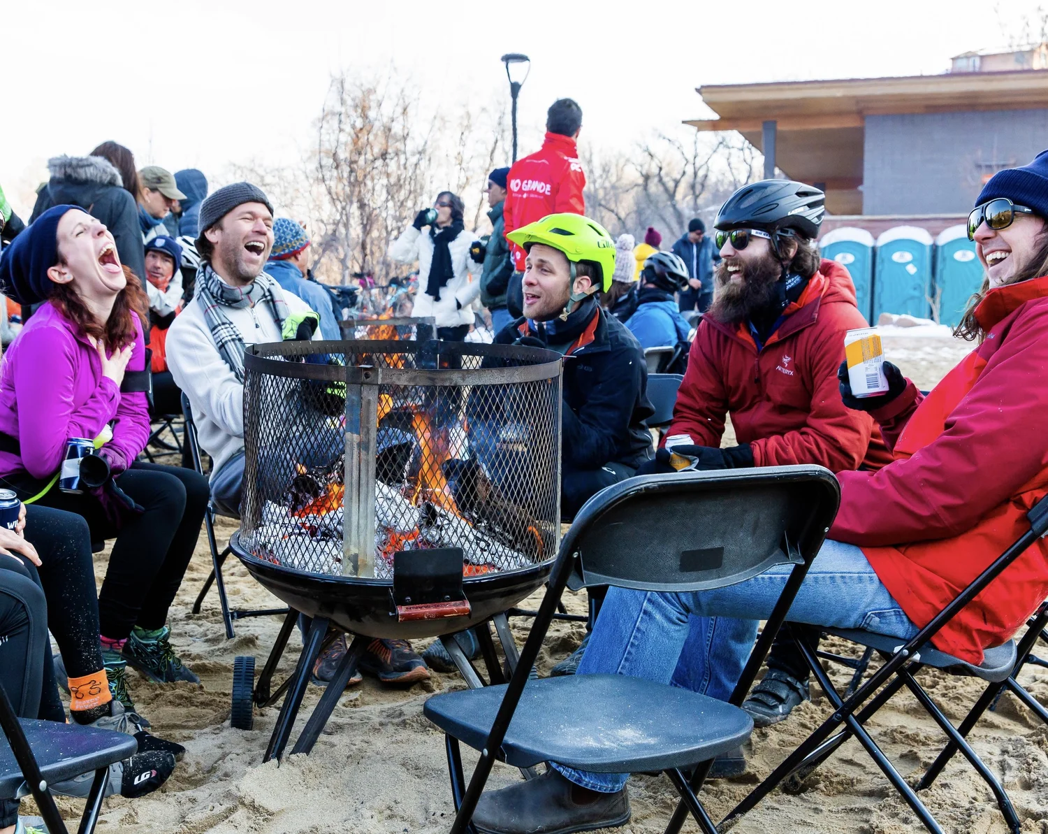 Friends talking and warming up at an event bonfire